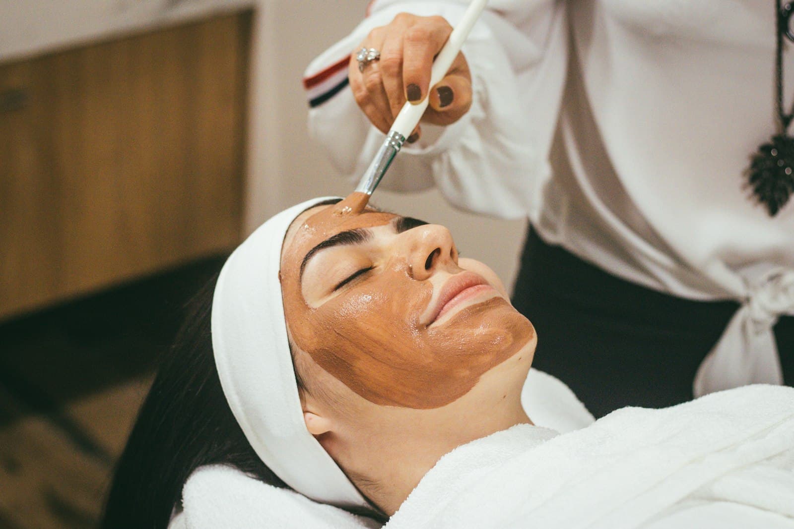 Cliente relaxando durante aplicação de máscara facial com pincel