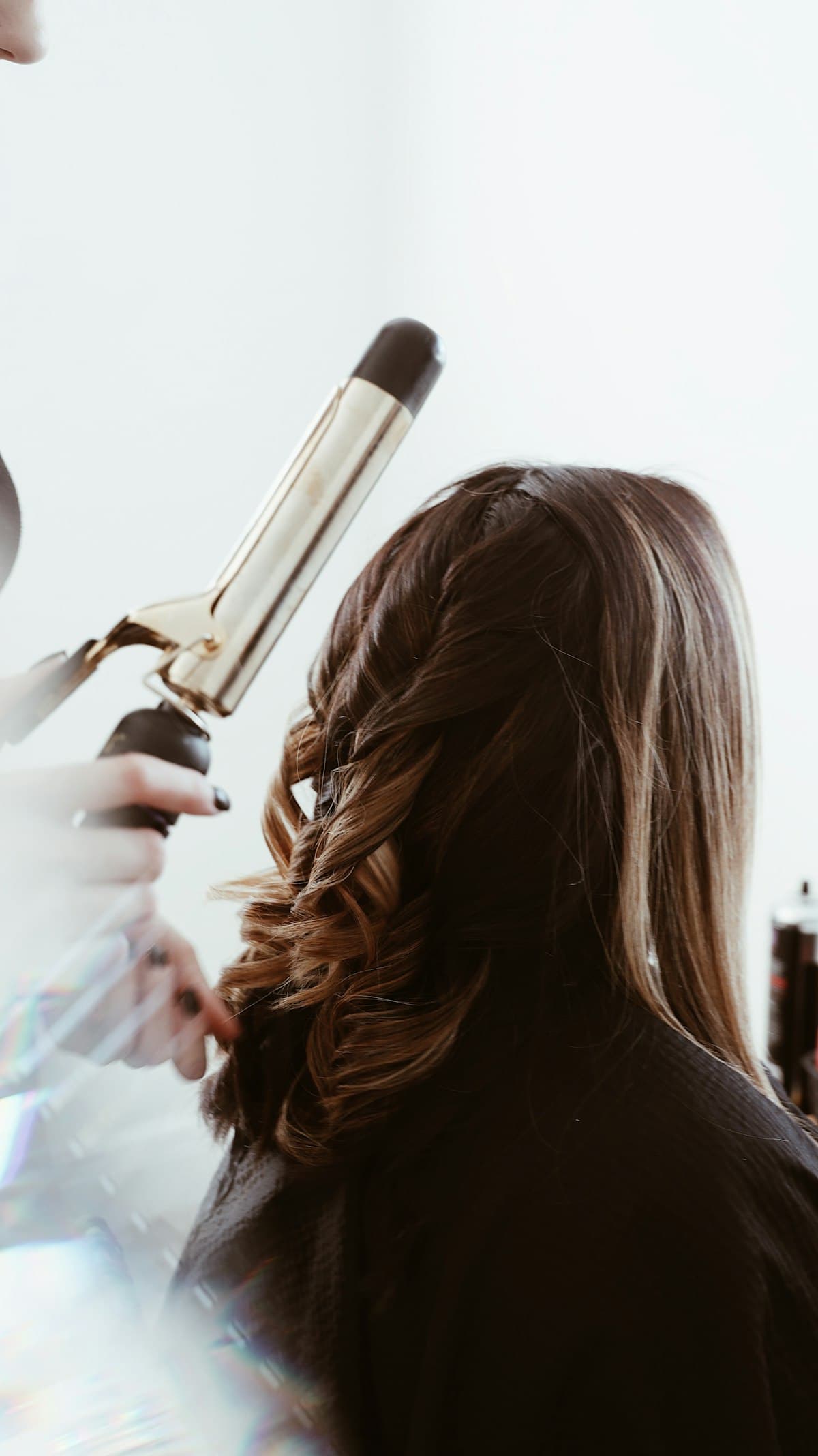 Cabelo castanho sendo modelado com babyliss