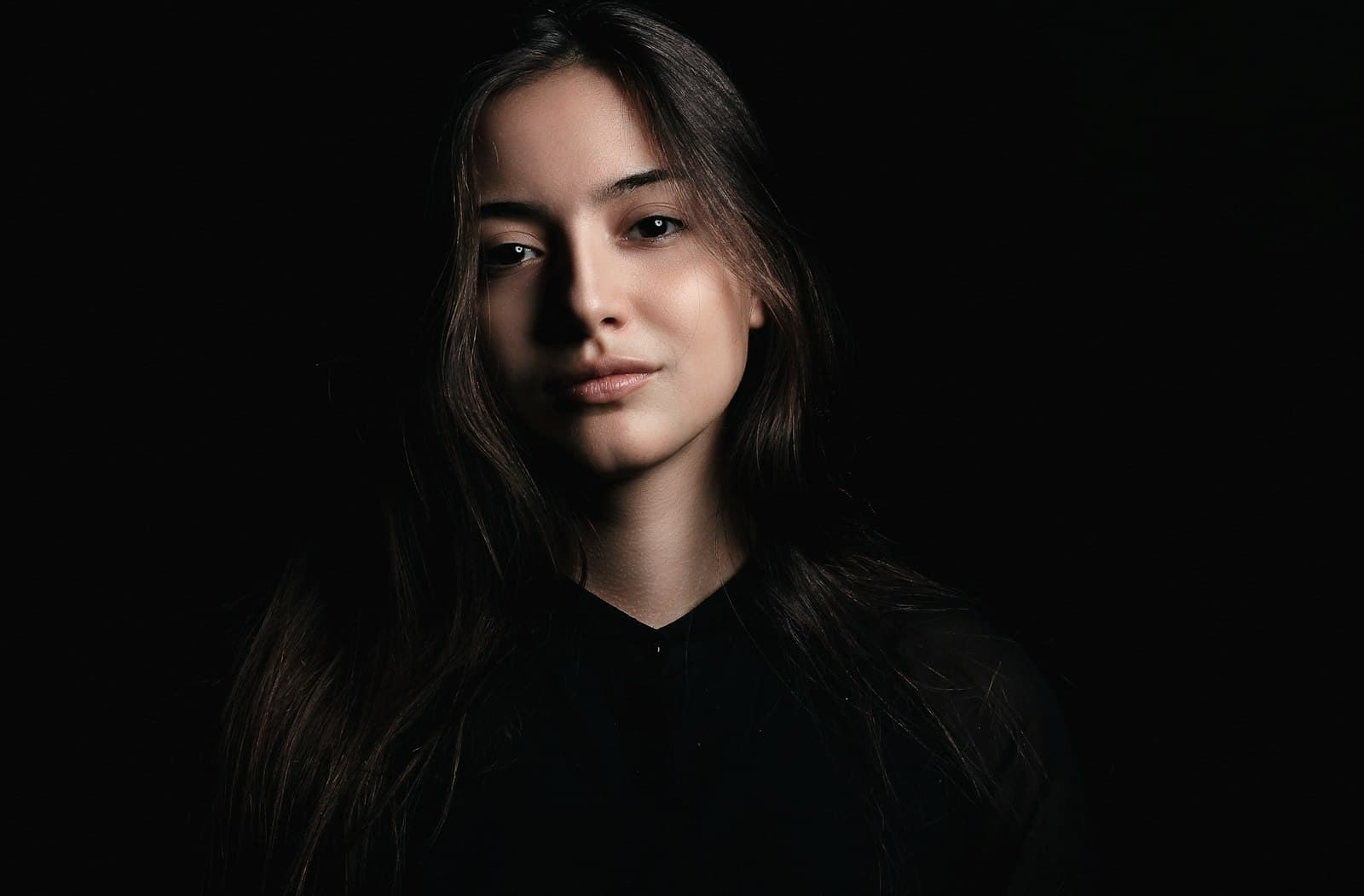 Retrato de Isabella Rocha, cabelos escuros, em fundo preto